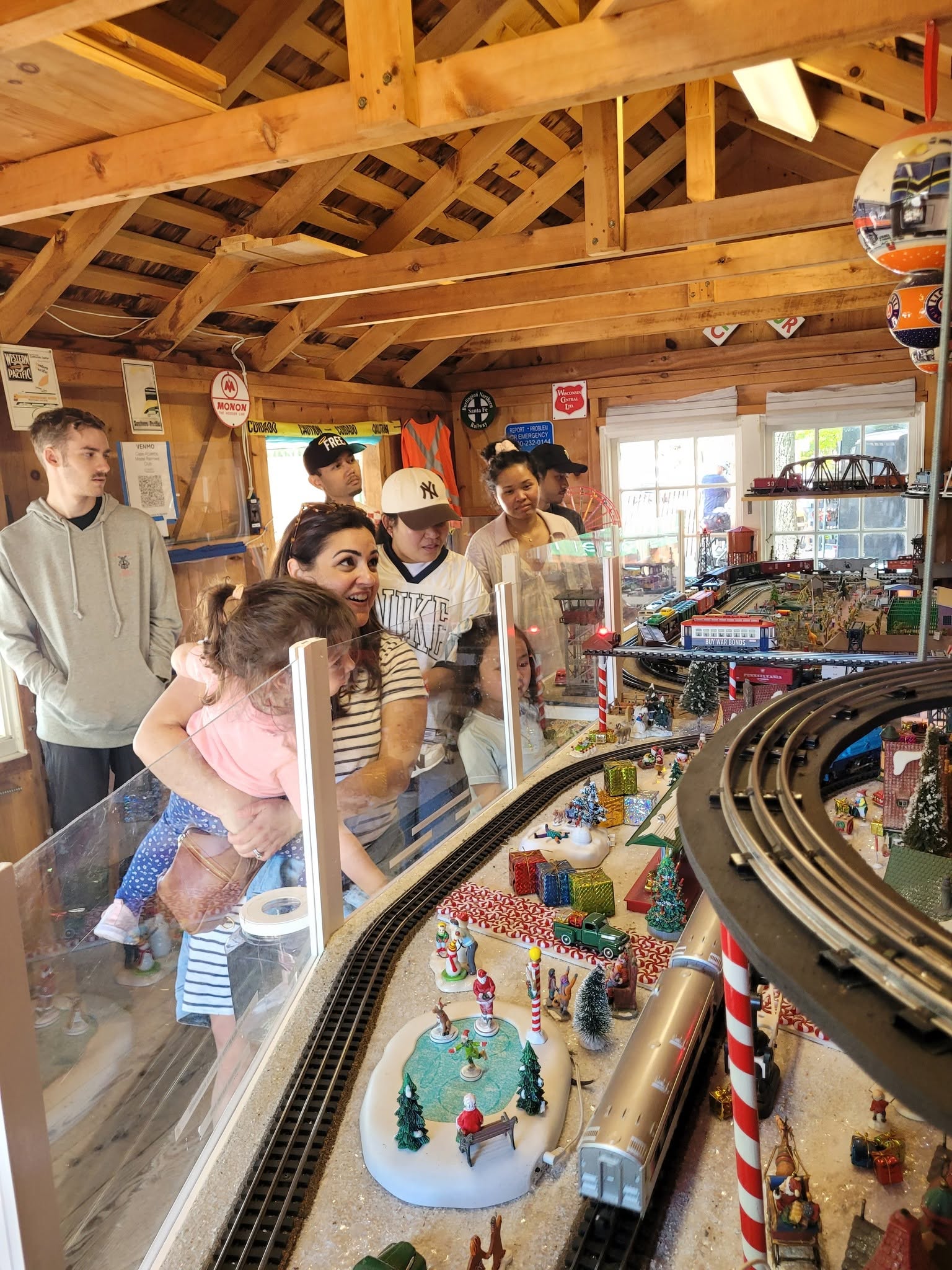 Model railroad town scene featuring detailed miniature buildings, roads, and landscaping along the tracks